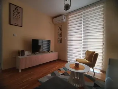 a living room with a television and a table at Vrnjački Kos in Vrnjačka Banja