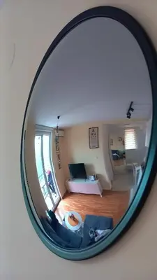a mirror reflection of a living room with a couch at Vrnjački Kos in Vrnjačka Banja