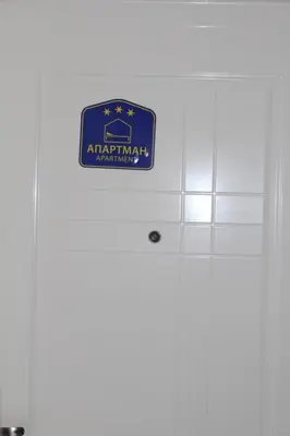 a sign on top of a white door at ZONA apartman in Vranje