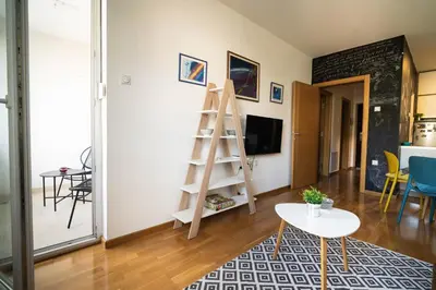 a living room with a ladder and a table at Apartment sPARK Niš in Niš