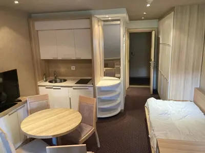 a small room with a kitchen and a table and a bed at Ski centar konaci Kopaonik in Kopaonik