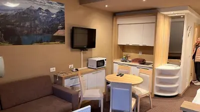 a room with a couch and a kitchen with a tv at Ski centar konaci Kopaonik in Kopaonik