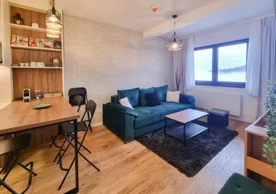 a living room with a blue couch and a table at Cozy Mountain Apartment VIDIK in Kopaonik