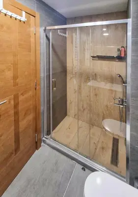 a bathroom with a shower with a toilet and a sink at Cozy Mountain Apartment VIDIK in Kopaonik