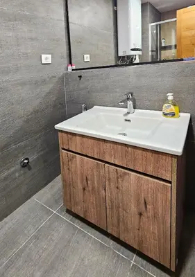 a bathroom with a white sink and a mirror at Cozy Mountain Apartment VIDIK in Kopaonik