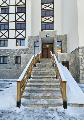 a set of stairs in front of a building with snow at Cozy Mountain Apartment VIDIK in Kopaonik