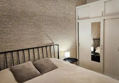 a bedroom with a bed and a brick wall at Cozy Mountain Apartment VIDIK in Kopaonik