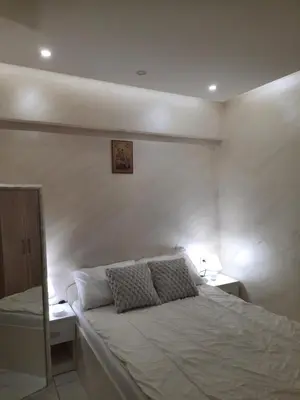 a bedroom with a white bed with two night stands at Center Apartment in Niš