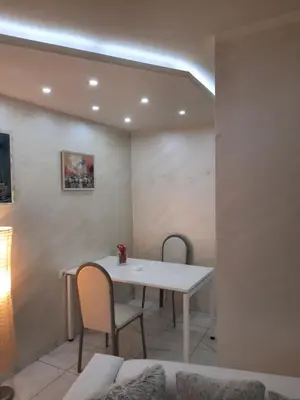 a dining room with a white table and two chairs at Center Apartment in Niš