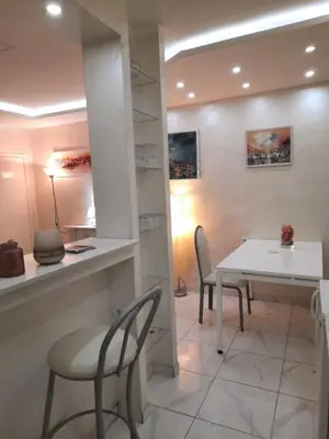a dining room with a white table and chairs at Center Apartment in Niš