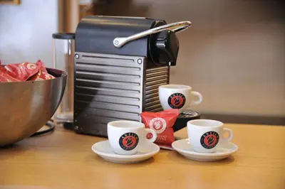 three coffee cups on a counter with a coffee maker at Apartman Family Konaci in Kopaonik