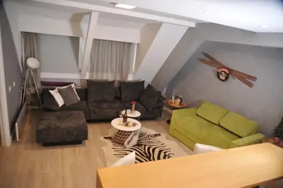 a living room with a couch and a table at Apartman Family Konaci in Kopaonik