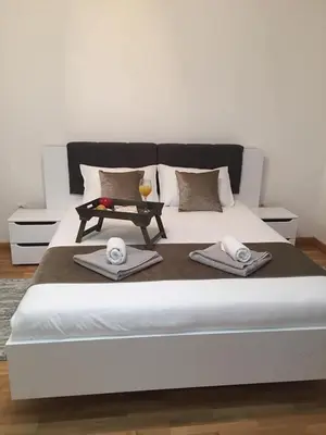 a bed with two towels and a table on it at Park app in Vrnjačka Banja