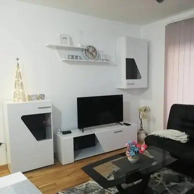 a living room with a television and a white entertainment center at Park app in Vrnjačka Banja