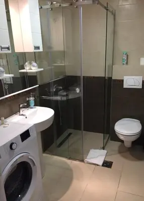 a bathroom with a shower and a toilet and a washing machine at Park app in Vrnjačka Banja