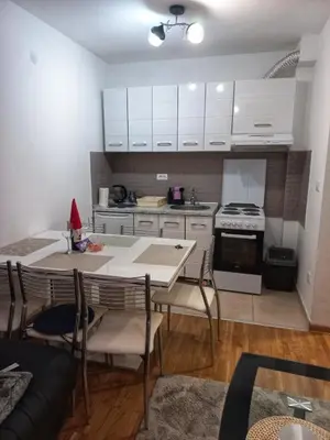 a kitchen with a table and chairs in a room at Park app in Vrnjačka Banja