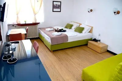a bedroom with a bed and a table in it at ApartHotel Kopaonik in Brzeće