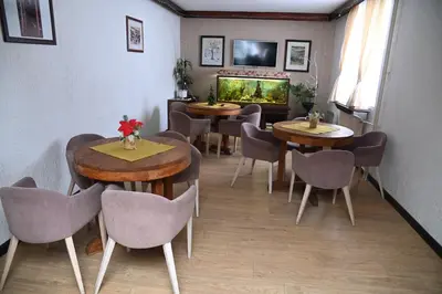 a restaurant with tables and chairs and a fish tank at ApartHotel Kopaonik in Brzeće