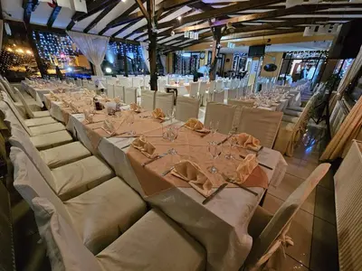a long table in a room with white tables and chairs at ApartHotel Kopaonik in Brzeće