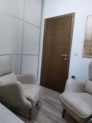 a living room with two chairs and a door at Jagodina apartman MM AKVA PARK free garaža in Jagodina