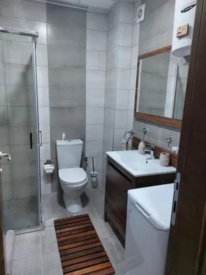 a bathroom with a toilet and a sink and a shower at Jagodina apartman MM AKVA PARK free garaža in Jagodina