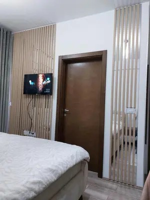 a bedroom with a bed and a flat screen tv at Jagodina apartman MM AKVA PARK free garaža in Jagodina