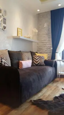 a brown couch in a living room with blue curtains at Visnja Apartment in Kopaonik