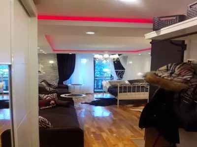 a living room with a red ceiling and a room with a couch at Visnja Apartment in Kopaonik