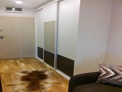 a room with a couch and a glass wall at Visnja Apartment in Kopaonik