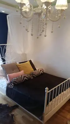 a bed in a bedroom with a chandelier at Visnja Apartment in Kopaonik