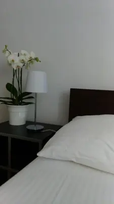 a bedroom with a bed and a table with a vase of flowers at Vrnjci House in Vrnjačka Banja
