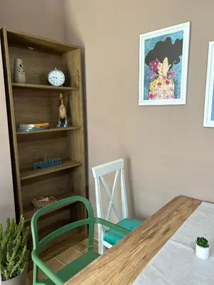 a dining room with a table and a clock on a shelf at San apartman in Vrnjci