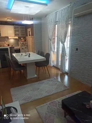 a kitchen and living room with a white table and chairs at Kuća na dan in Supnje