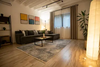 a living room with a couch and a table at Style and Shine Sunrise Apartment in Niš