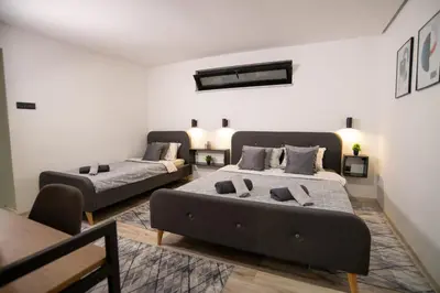 a bedroom with two beds and a table at Style and Shine Sunrise Apartment in Niš