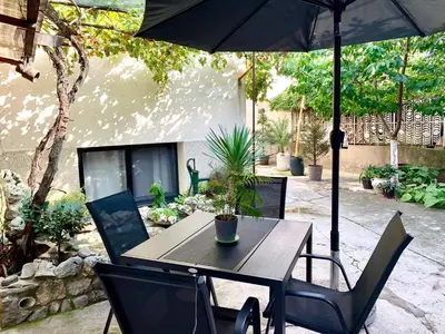 a table and chairs with an umbrella on a patio at Style and Shine Sunrise Apartment in Niš