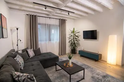 a living room with a couch and a tv at Style and Shine Sunrise Apartment in Niš