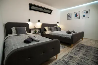 a bedroom with two beds and a couch at Style and Shine Sunrise Apartment in Niš