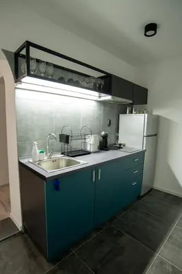 a kitchen with a sink and a refrigerator at Style and Shine Sunrise Apartment in Niš