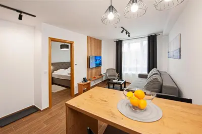 a living room with a table with a bowl of oranges on it at Apartman Kopaonik u Kraljevim Čardacima in Kopaonik