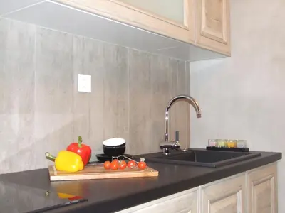 a kitchen counter with a sink and vegetables on a cutting board at Apartmani Kopaonik Centar Maglic in Kopaonik