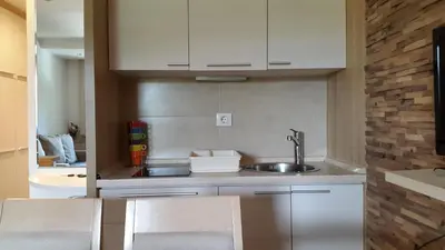 a kitchen with white cabinets and a sink at Apartmani Kopaonik Centar Maglic in Kopaonik