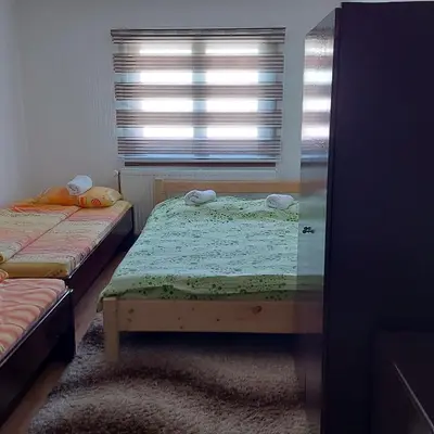 a small bedroom with two beds and a window at Nacionalna kuca Krstojevic in Raška