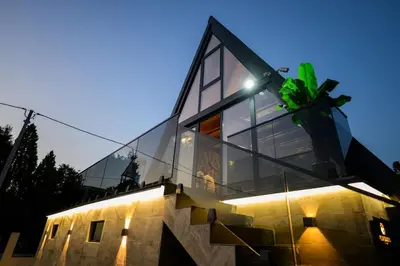 a glass house on top of a building at Luxurious cabin for couples with hot tub lake view in Aleksinac