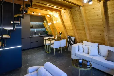 a living room with a white couch and a table at Luxurious cabin for couples with hot tub lake view in Aleksinac