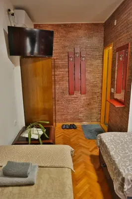 a room with two beds and red brick walls at Smeštaj Đorić in Leskovac