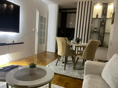 a living room with a couch and a table and chairs at Saric LuxApartman in Kruševac