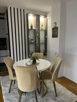 a dining room with a white table and chairs at Saric LuxApartman in Kruševac