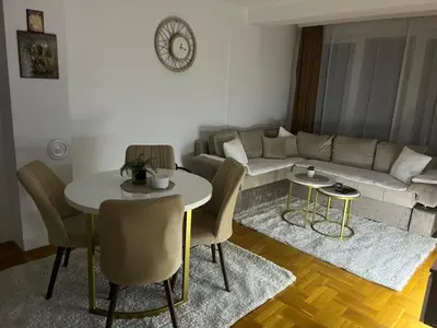 a living room with a couch and a table and chairs at Saric LuxApartman in Kruševac