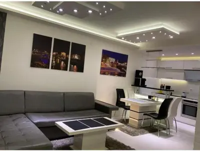 a living room with a couch and a table and a kitchen at Harmony in Niš